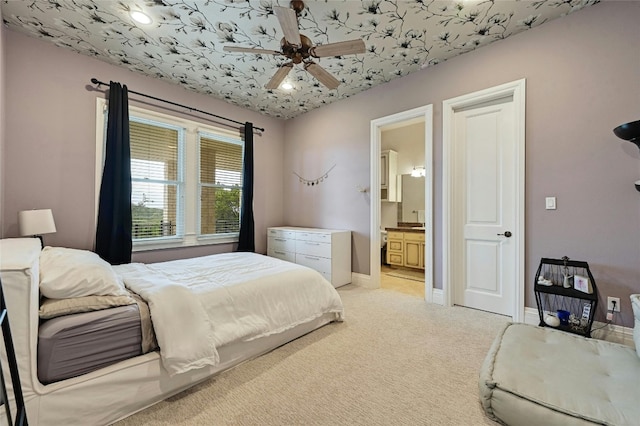 bedroom with ceiling fan, ensuite bathroom, and light carpet