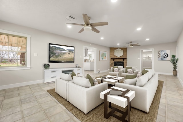 tiled living room featuring brick wall, a fireplace, and ceiling fan