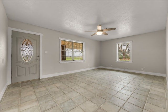 entryway with light tile floors, ceiling fan, and a wealth of natural light