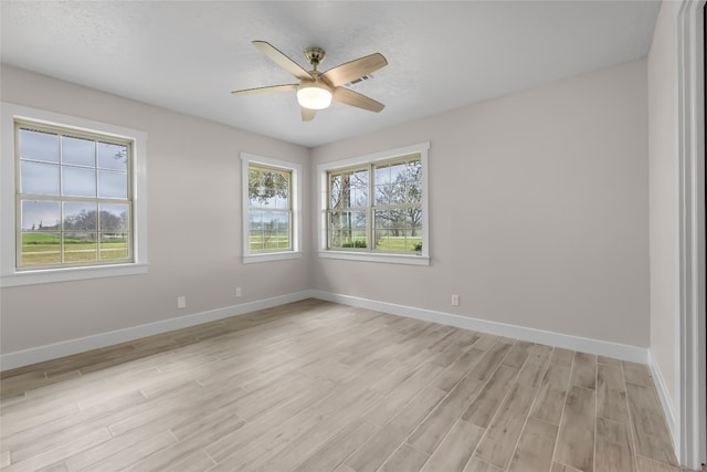 empty room with ceiling fan, light hardwood / wood-style flooring, and a wealth of natural light