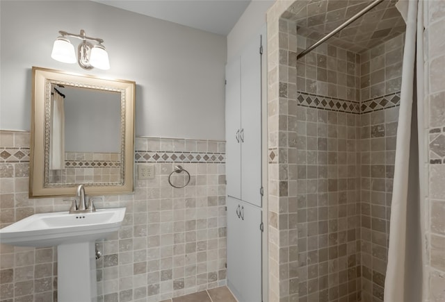 bathroom featuring tile walls, sink, tasteful backsplash, and walk in shower