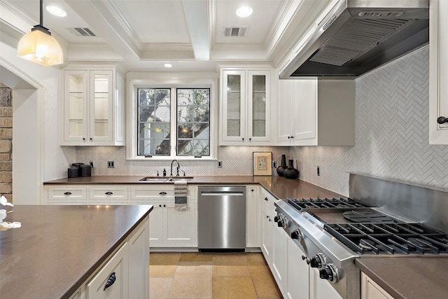 kitchen featuring pendant lighting, appliances with stainless steel finishes, wall chimney range hood, white cabinetry, and sink