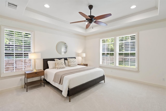 bedroom featuring ceiling fan, carpet, a raised ceiling, and multiple windows