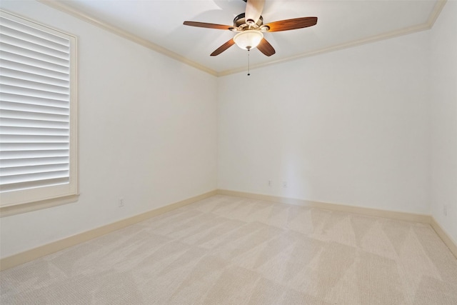 carpeted empty room featuring ceiling fan and crown molding