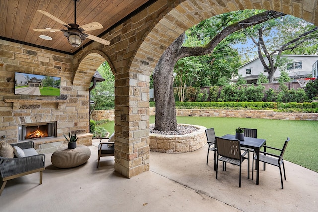 view of patio with ceiling fan and an outdoor stone fireplace