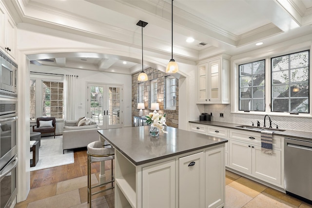 kitchen featuring tasteful backsplash, white cabinetry, hanging light fixtures, appliances with stainless steel finishes, and french doors