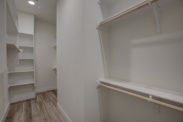 walk in closet with light hardwood / wood-style flooring