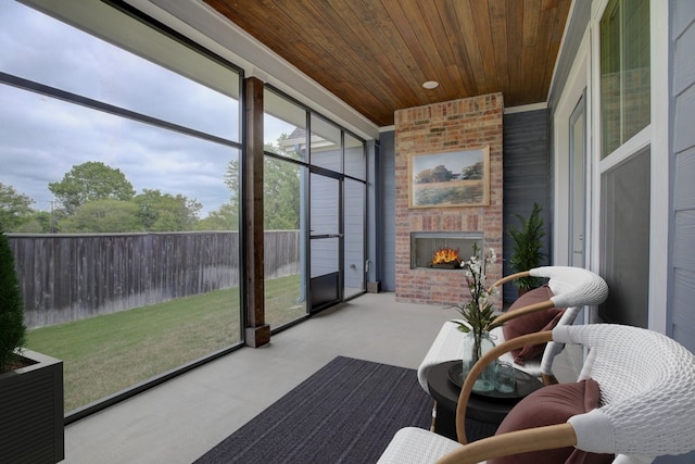 sunroom / solarium with an outdoor brick fireplace and wooden ceiling