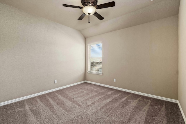 unfurnished room with dark colored carpet, ceiling fan, and vaulted ceiling