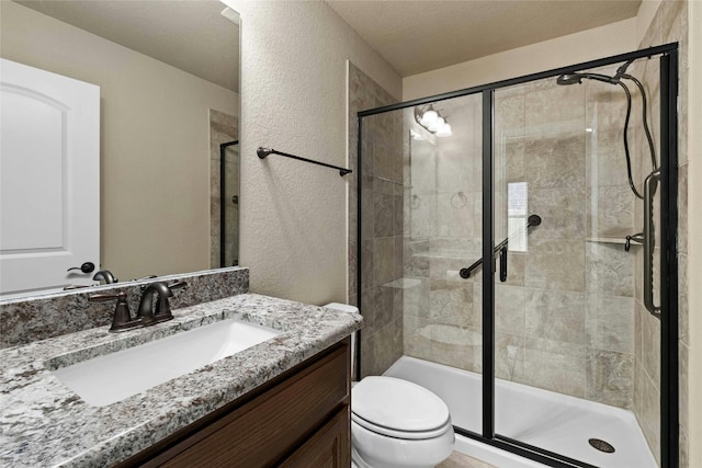 bathroom featuring toilet, vanity, and an enclosed shower