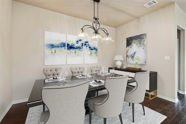 dining area featuring an inviting chandelier and dark hardwood / wood-style flooring