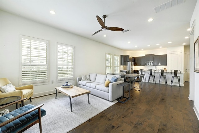 living room featuring dark hardwood / wood-style flooring and ceiling fan