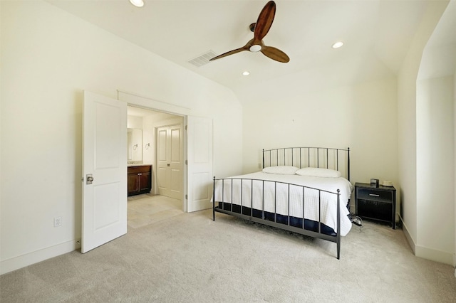 bedroom with lofted ceiling, ceiling fan, connected bathroom, and light colored carpet