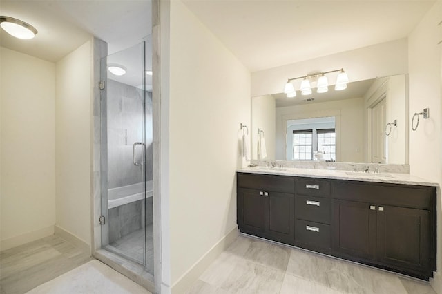 bathroom with tile floors, vanity with extensive cabinet space, double sink, and an enclosed shower