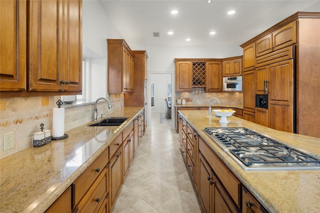 kitchen with appliances with stainless steel finishes, backsplash, and light stone countertops