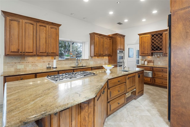 kitchen featuring sink, tasteful backsplash, light tile flooring, stainless steel appliances, and light stone countertops