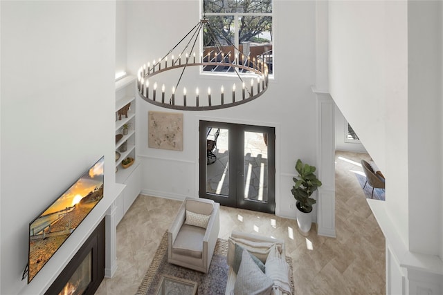 foyer entrance with a notable chandelier, light tile floors, and a high ceiling