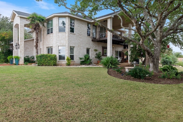 view of front facade with a balcony and a front yard