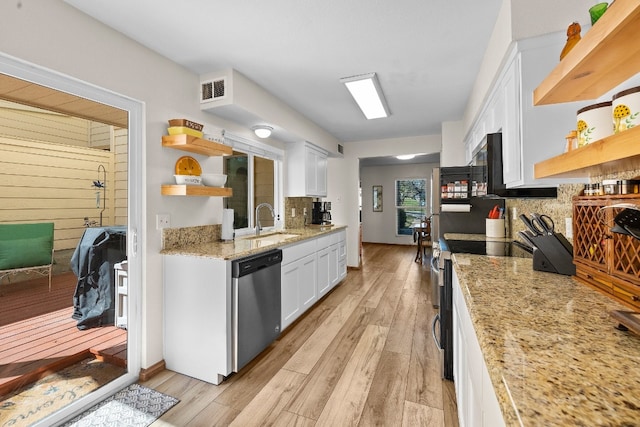 kitchen with sink, light wood-type flooring, stainless steel appliances, white cabinets, and light stone counters