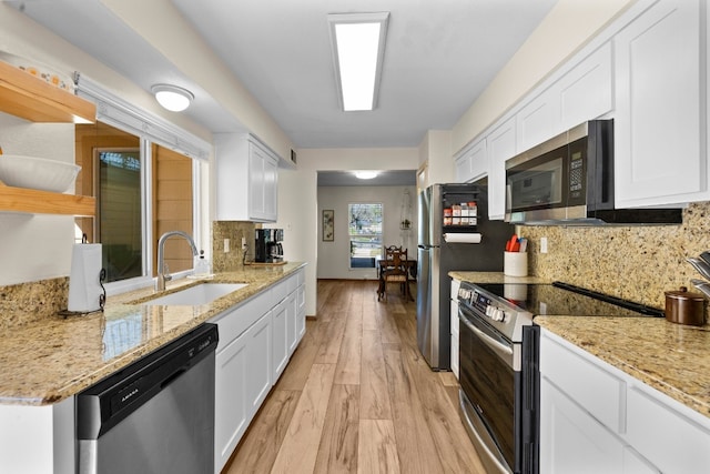 kitchen with white cabinetry, tasteful backsplash, stainless steel appliances, and light stone counters