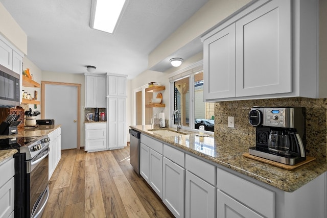 kitchen with sink, stainless steel appliances, backsplash, and white cabinetry