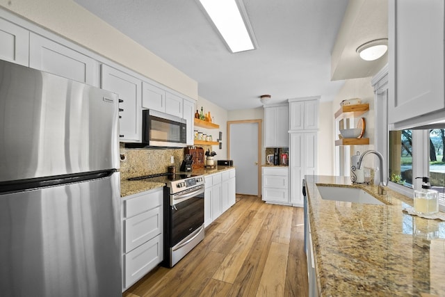 kitchen with white cabinets, backsplash, stainless steel appliances, and sink