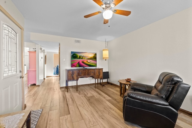 living area with ceiling fan and light hardwood / wood-style flooring