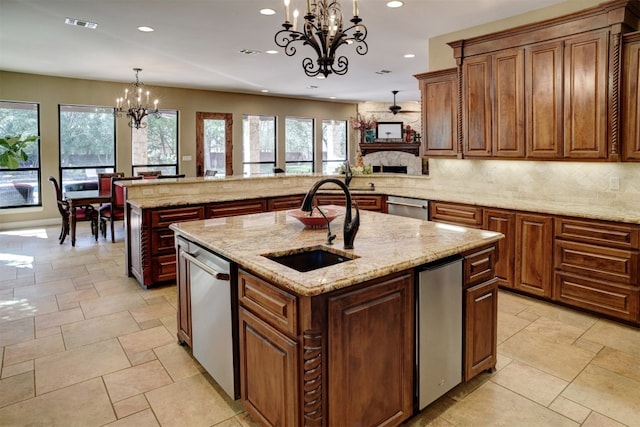 kitchen with a chandelier, pendant lighting, a center island with sink, and a wealth of natural light