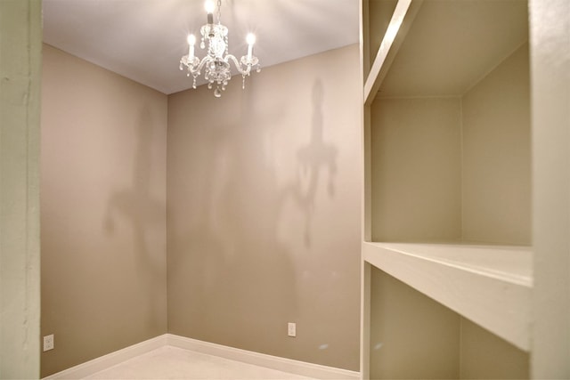 unfurnished room with an inviting chandelier