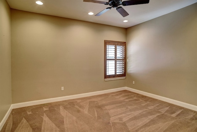 carpeted spare room featuring ceiling fan