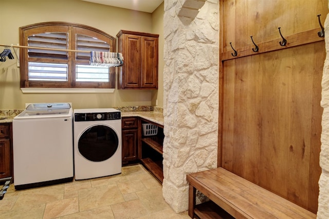 washroom featuring light tile floors, cabinets, and washer and dryer