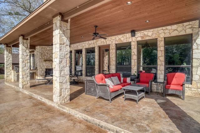 view of patio with an outdoor living space with a fireplace and ceiling fan