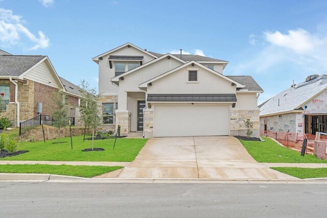 view of front of property featuring a garage and a front lawn