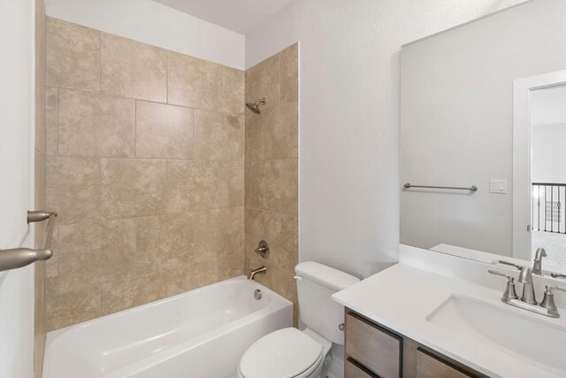 full bathroom with tiled shower / bath, toilet, and vanity