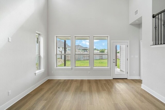 interior space with light wood-type flooring and a high ceiling