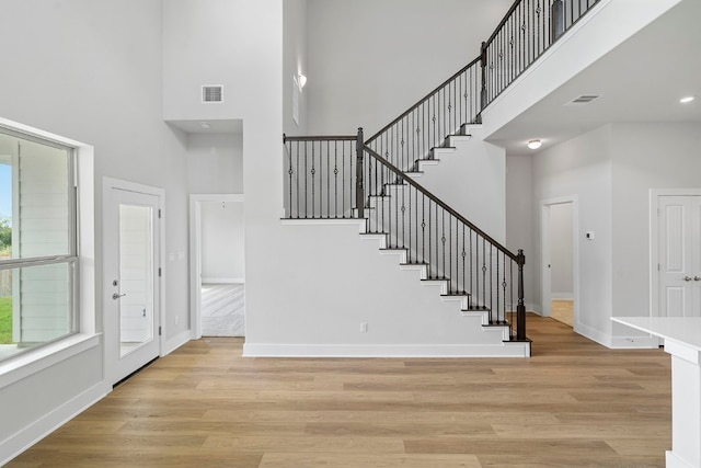 interior space featuring light hardwood / wood-style flooring and a towering ceiling