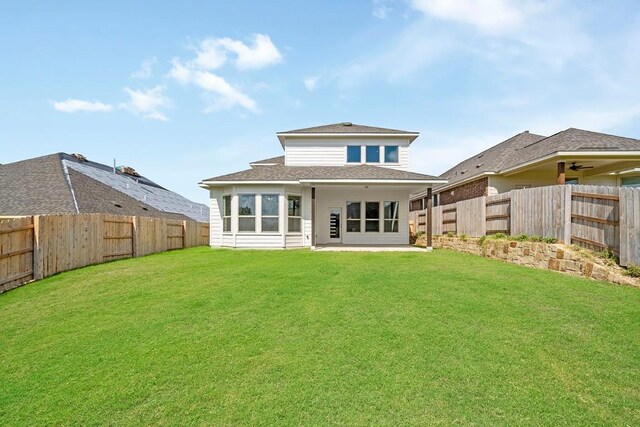 back of house featuring a patio area and a lawn