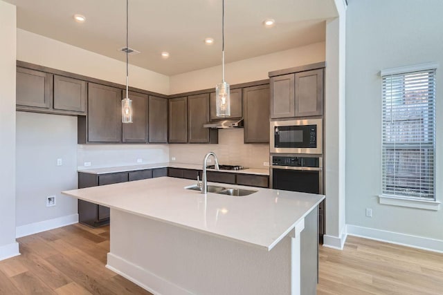 316 Chaste Tree Dr, San Marcos, TX 78666 - kitchen featuring built in microwave, oven, a sink, baseboards, and light wood-style floors