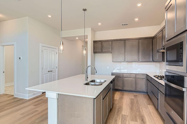 316 Chaste Tree Dr, San Marcos, TX 78666 - kitchen with a sink, stainless steel oven, light wood-type flooring, built in microwave, and recessed lighting