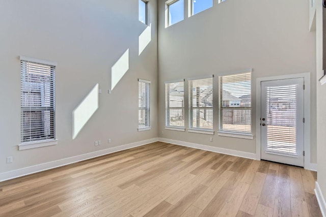 316 Chaste Tree Dr, San Marcos, TX 78666 - unfurnished living room featuring a high ceiling, baseboards, and light wood-style flooring
