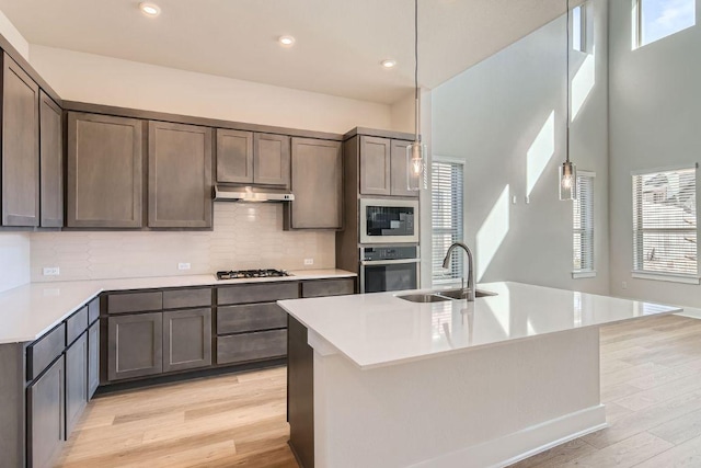 316 Chaste Tree Dr, San Marcos, TX 78666 - kitchen with stainless steel oven, a sink, under cabinet range hood, healthy amount of natural light, and recessed lighting