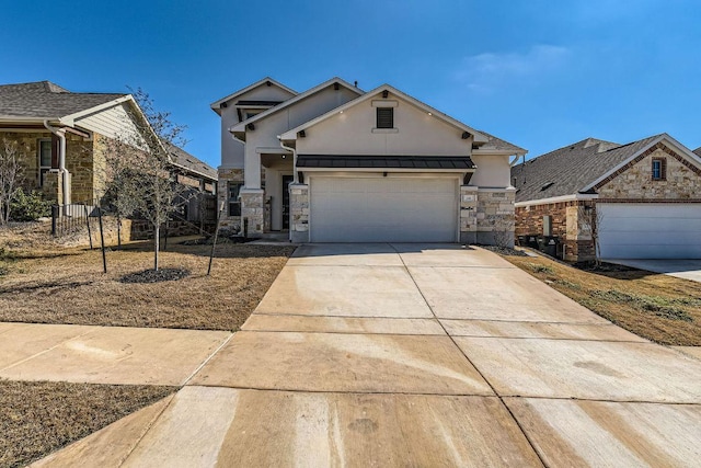 316 Chaste Tree Dr, San Marcos, TX 78666 - view of front of home featuring stone siding, stucco siding, driveway, a standing seam roof, and an attached garage