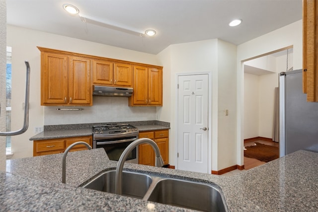 kitchen with sink, dark stone counters, and appliances with stainless steel finishes