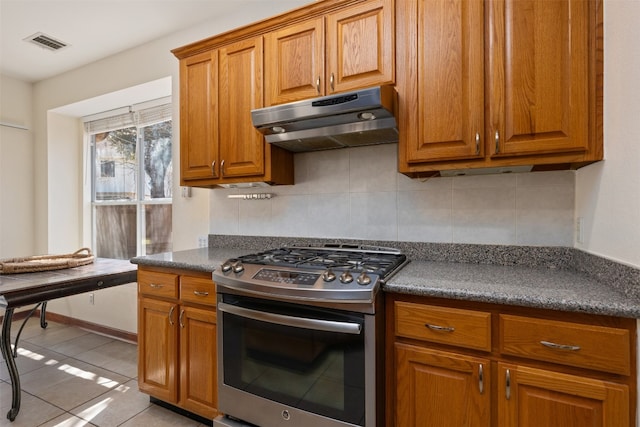 kitchen with tasteful backsplash, gas range, and light tile patterned flooring