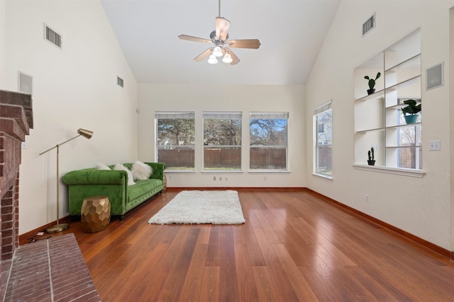 unfurnished living room with hardwood / wood-style flooring, ceiling fan, and high vaulted ceiling