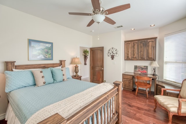 bedroom featuring ceiling fan, dark wood-type flooring, and multiple windows