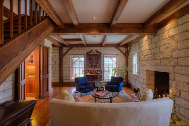 living room with a fireplace, beam ceiling, and light hardwood / wood-style flooring