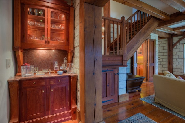 bar with beam ceiling, backsplash, and dark hardwood / wood-style flooring