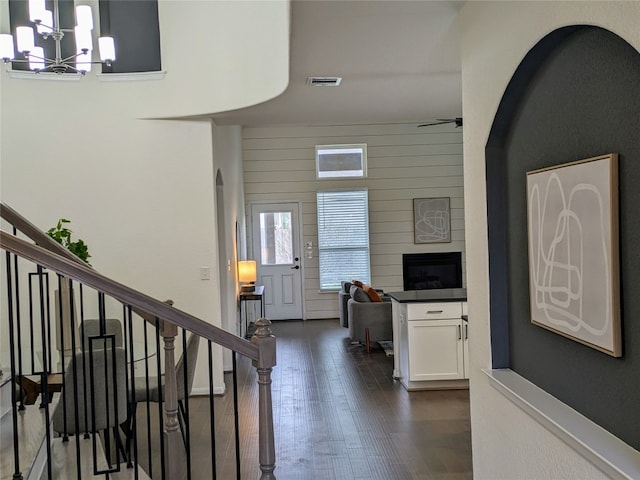 entrance foyer featuring ceiling fan with notable chandelier, a towering ceiling, and dark hardwood / wood-style flooring