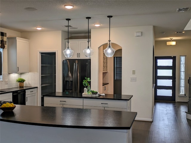 kitchen featuring white cabinetry, stainless steel fridge, dark wood-type flooring, tasteful backsplash, and pendant lighting